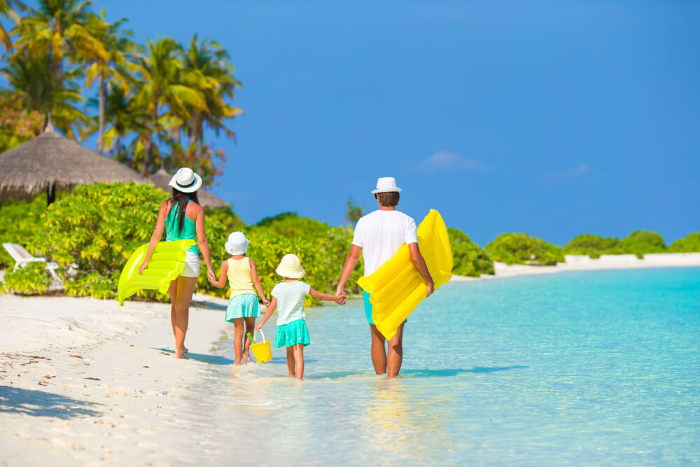Photo of family at the beach experiencing the top things to do in Aruba with kids